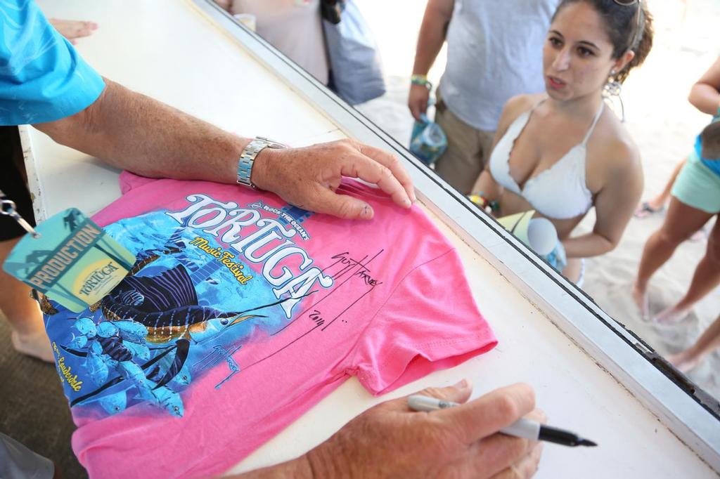 Guy Harvey autographing fan’s shirt at Tortuga Music Festival. © George Schellenger